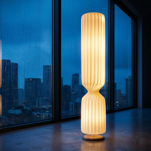 The Vespera - Luminor Arc
Vespera floor lamp featuring a tall, sculptural pleated shade that casts a warm 2700K amber glow against a deep blue hour window with rain droplets.